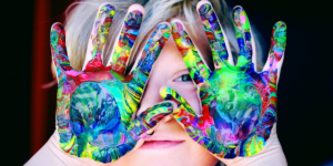 Image of child holding up hands with colour paint Image of child holding up hands with colour paint