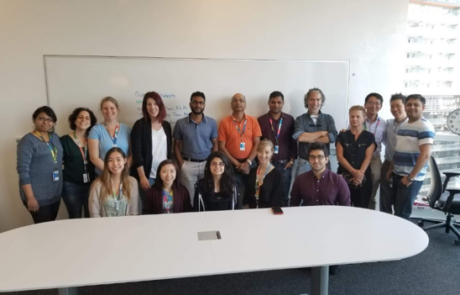Group shot of all the lab members with Dr. Christopher Pearson behind a long table.
