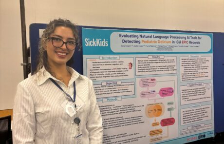 Female student smiling standing beside a research poster at a conference.
