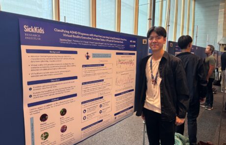 Student standing beside a research poster board at a conference.