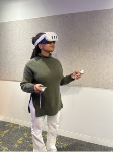Capture A person standing in a lab space wearing a VR headset and holding two hand controllers.