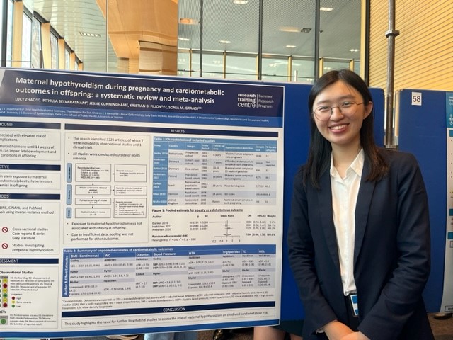 Lucy Zhao standing in front of her poster at the SSuRe Symposium