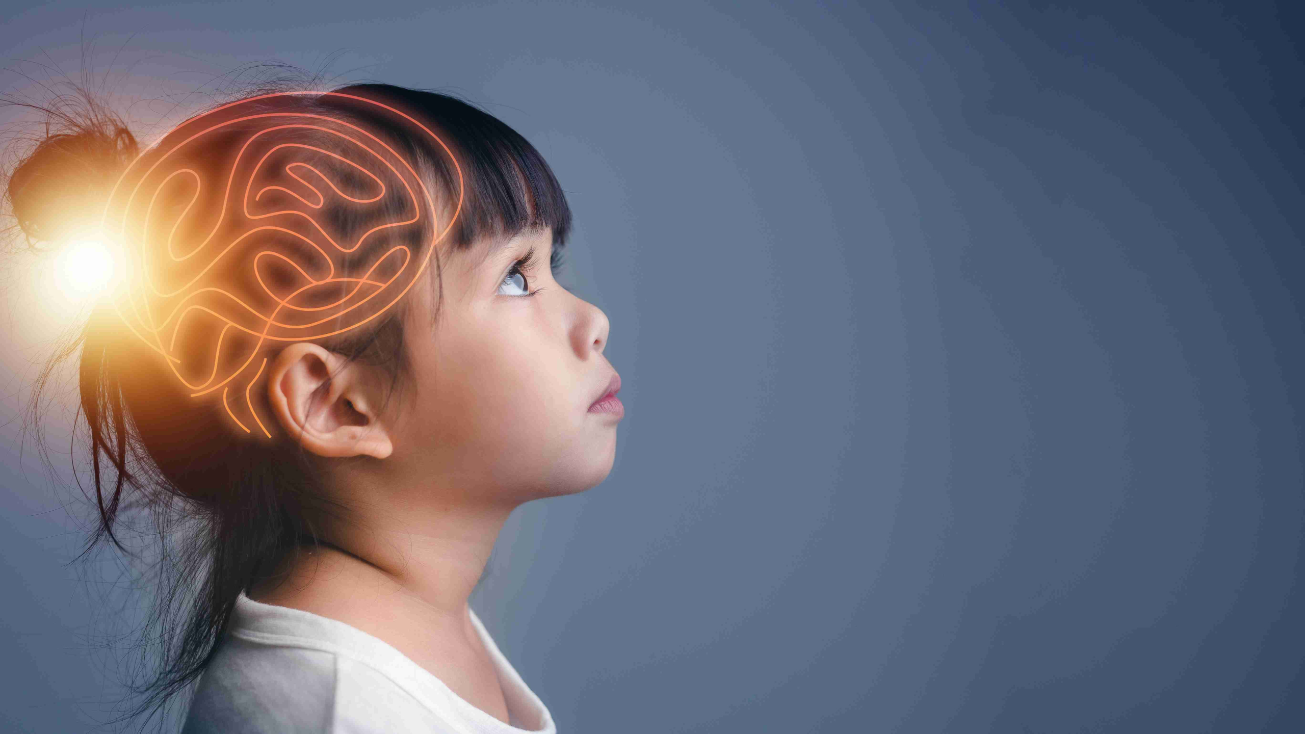 A side profile of a child. A glowing illustration of a brain is overlaid on the child's head.