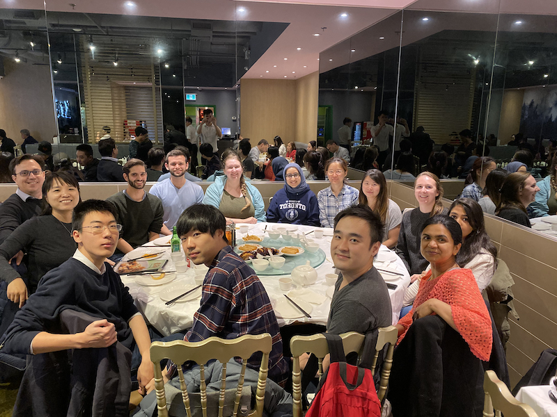 Members of the Li and Muffat labs sitting around the table at a restaurant for a lab lunch in 2019.