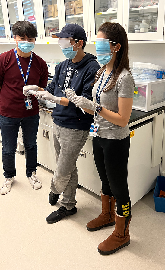 Photo of lab member observing 2 blindfolded lab members during Lab Olympics