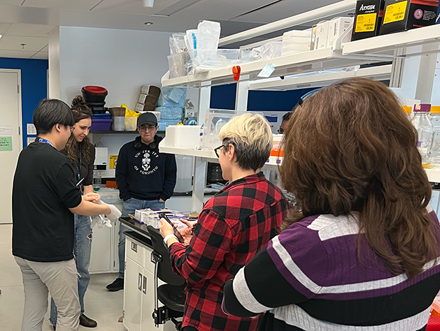 Photo of lab members playing a game while others watch during Lab Olympics