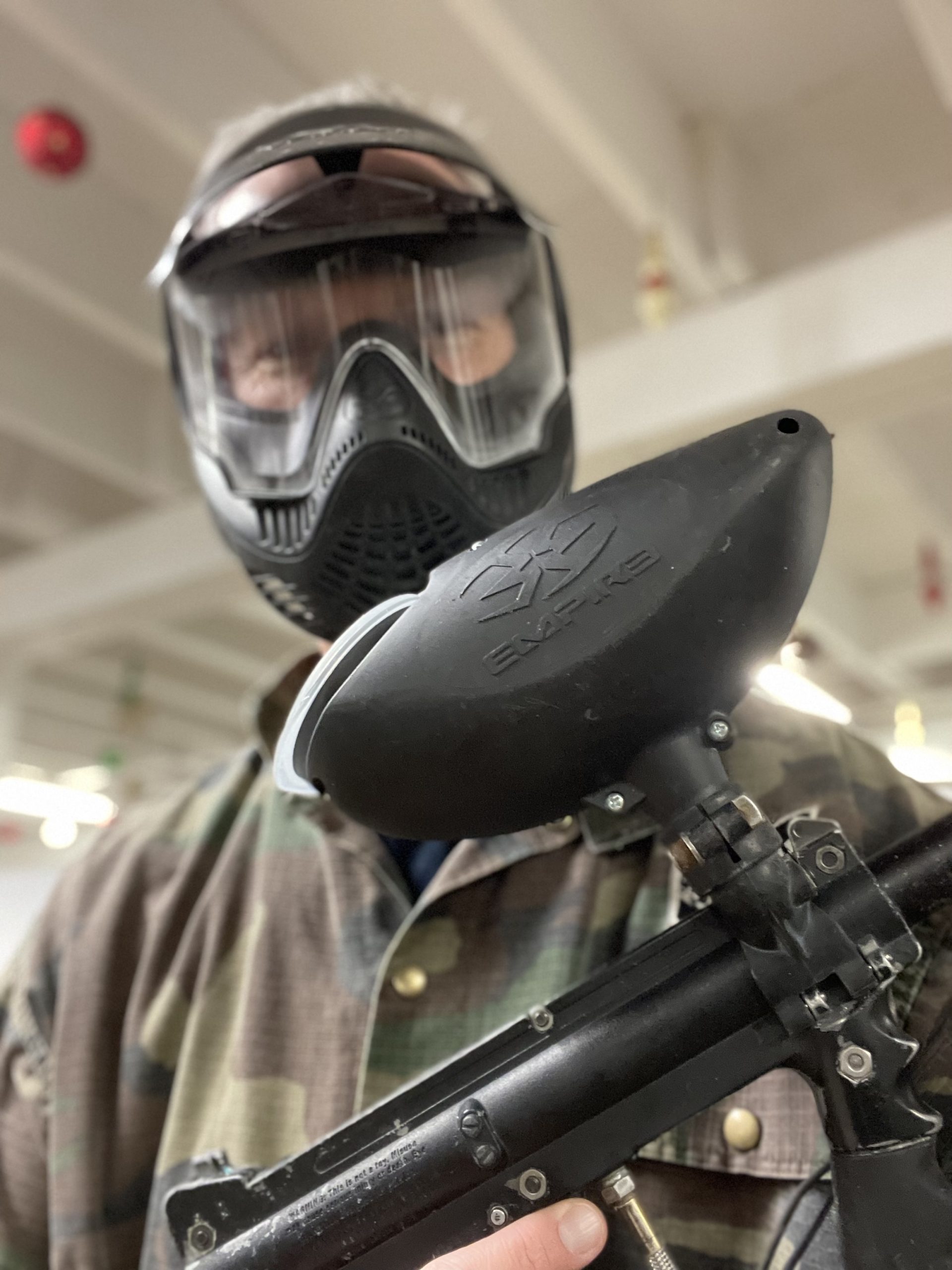 Lab member Kevin Brown holding a paintball gun at paintball