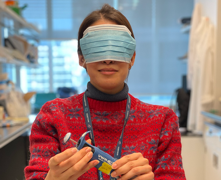 Photo of lab member Sanna Masud blindfolded with a face mask for a game during Lab Olympics