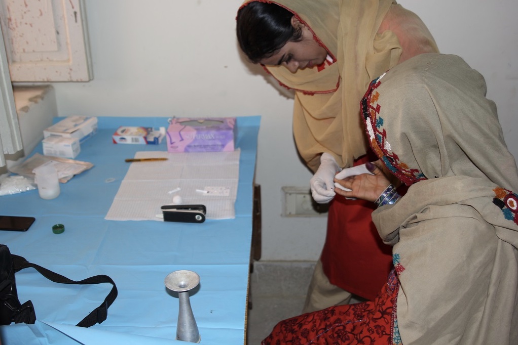 A lady health visitor performing the point of care EldonCard blood test on study participant