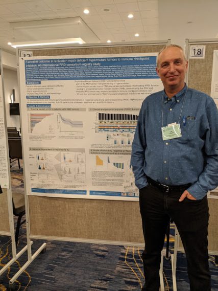 Dr. Uri Tabori standing next to his poster titled "favourable outcome in replication repair deficient hypermutant tumours to immune checkpoint inhibition: a replication repair deficiency consortium study" at the Gordon Research Conference for DNA Damage