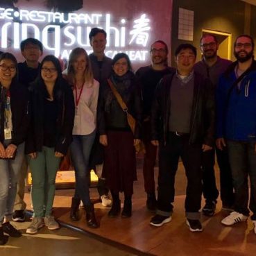 Several lab members standing together in the lobby of a restaurant